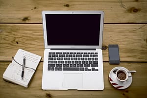 Translations on computer with phone and coffee
